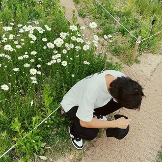 namjoon (bts) crouching at flowerbed